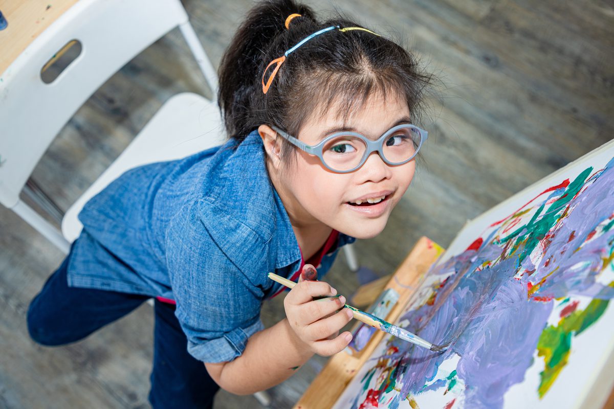 Young student painting on an easel in art class