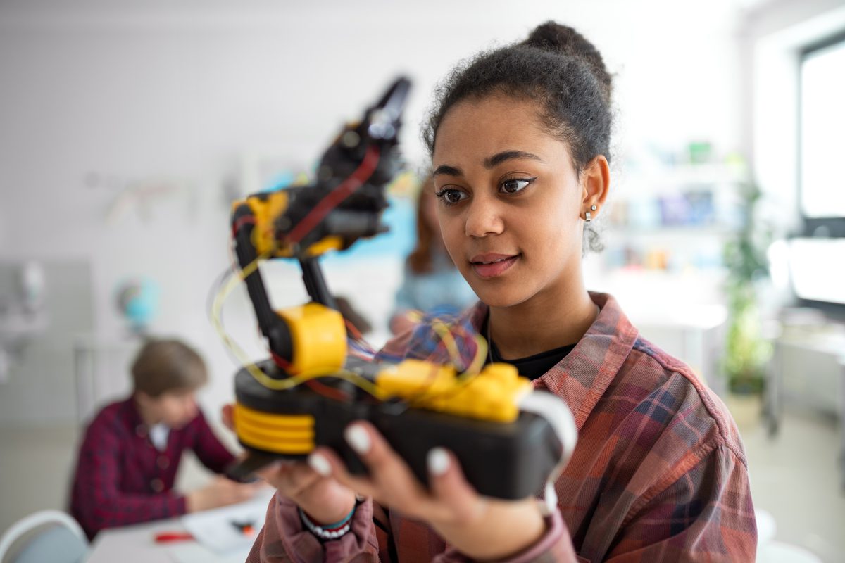 Student examining a robotics project in STEM class